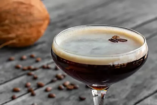Espresso martini in coupe glass garnished with coffee beans
