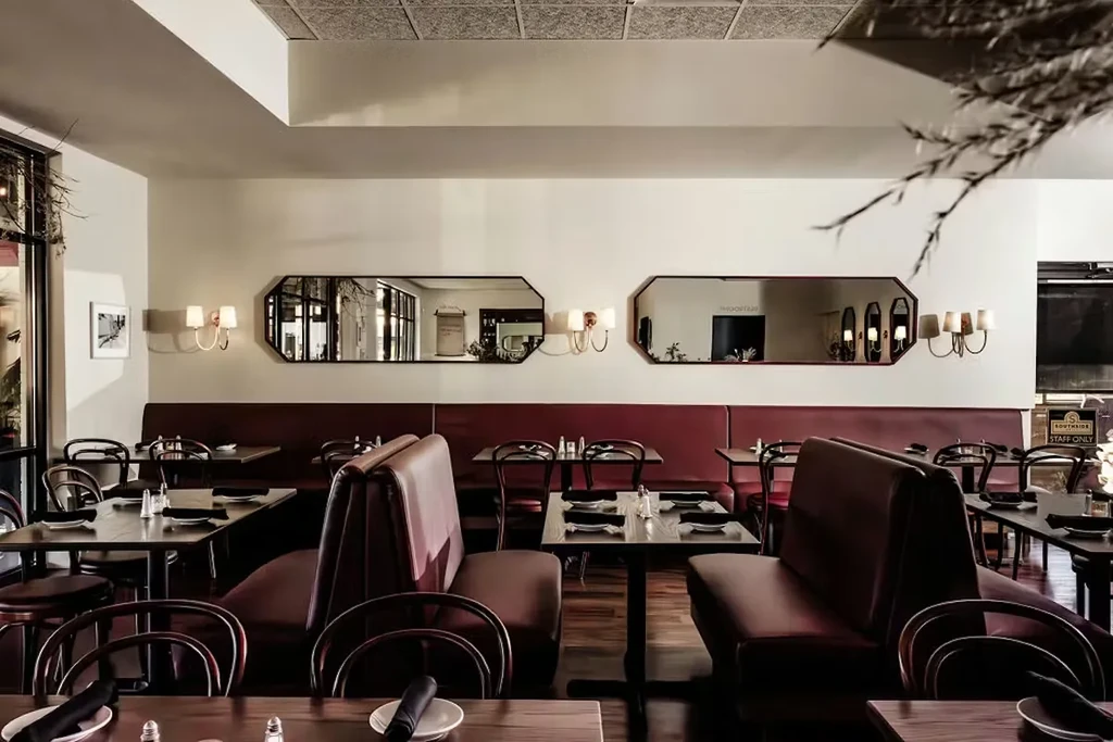 Empty restaurant with dark tables, red booths, and STAFF ONLY sign.