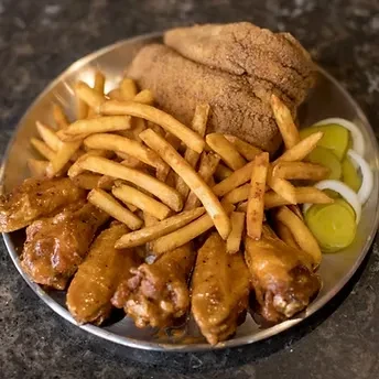 Platter of crispy fried fish, chicken wings, fries, and pickles.