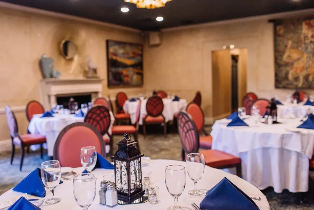 Meticulously set round table with blue napkins in an elegant restaurant.