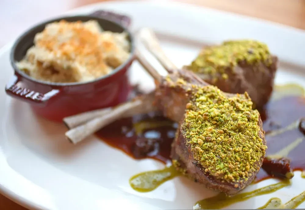 Rack of lamb with pistachio crust and a side of mac and cheese.