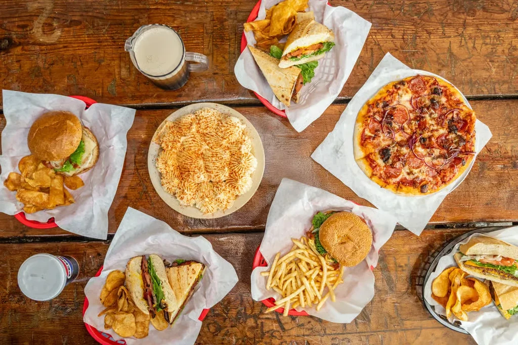 An overhead shot of several restaurant meals on a wooden table.