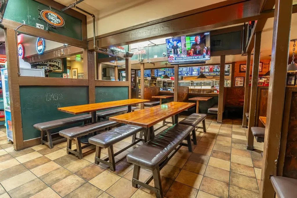Interior view of a casual restaurant with wooden tables and benches.