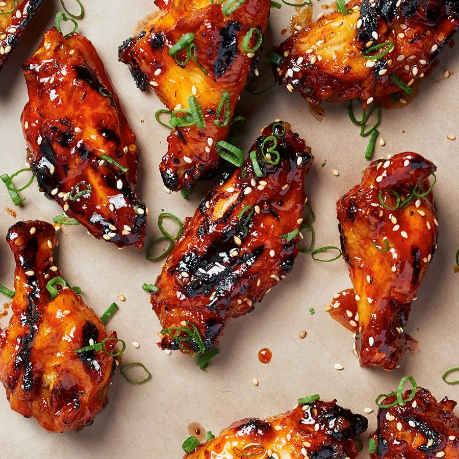 Sweet and spicy chicken wings with sesame seeds and green onions.