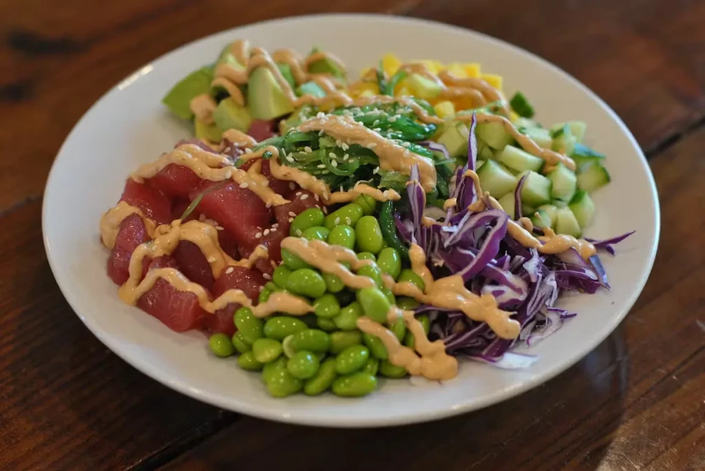 A white plate with a colorful tuna poke bowl.