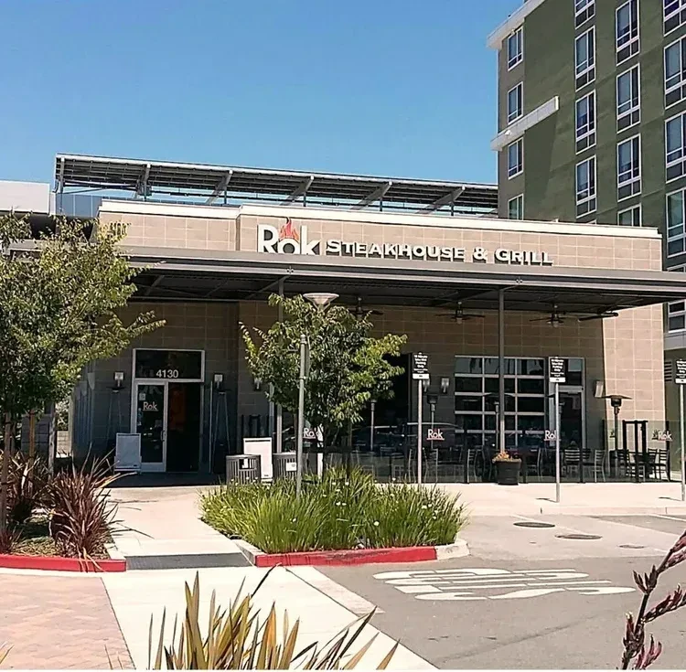 Rok Steakhouse & Grill building with solar panels and an apartment building.