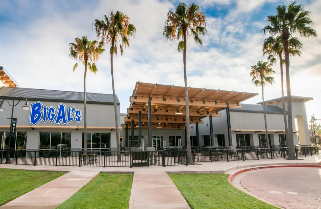 Big Al's restaurant building with a large outdoor patio and palm trees.