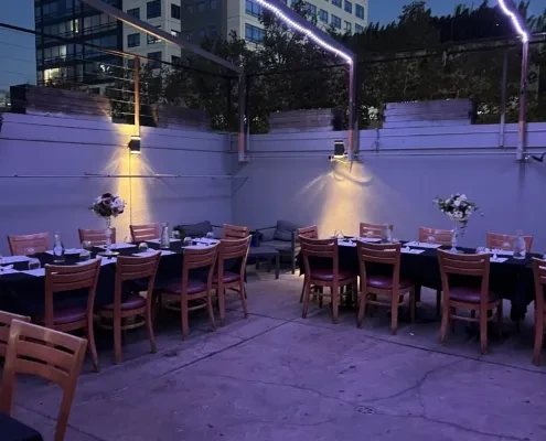 Outdoor patio dining area with tables set for a dinner party.