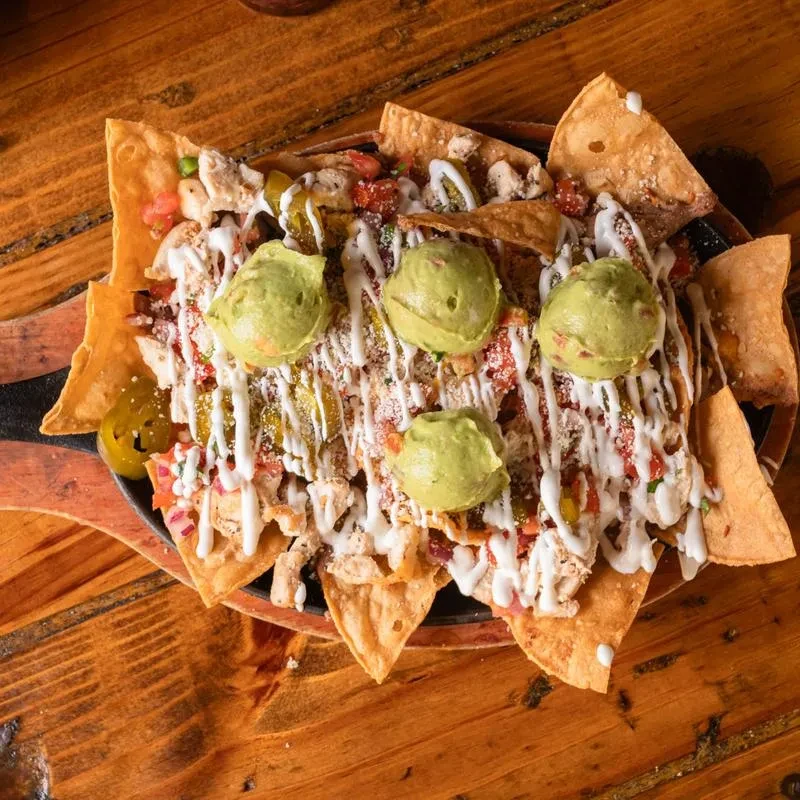 Loaded chicken nachos with guacamole, sour cream, and jalapeños.