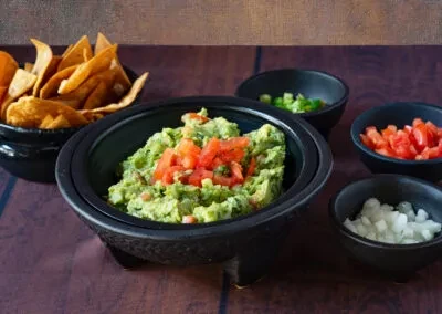 Guacamole with tortilla chips, chopped tomatoes, onions, and jalapeños.
