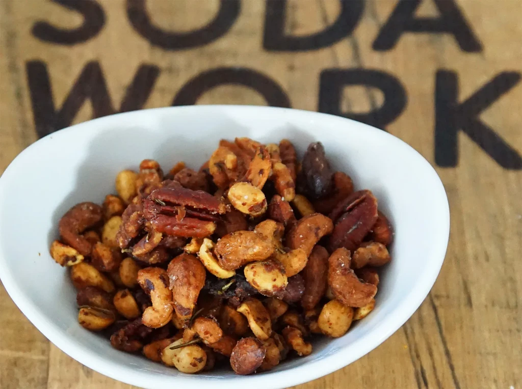 A white bowl filled with spicy mixed nuts.