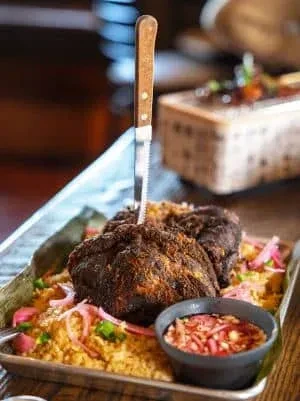 Savory meat with rice and vegetables on a metal platter.