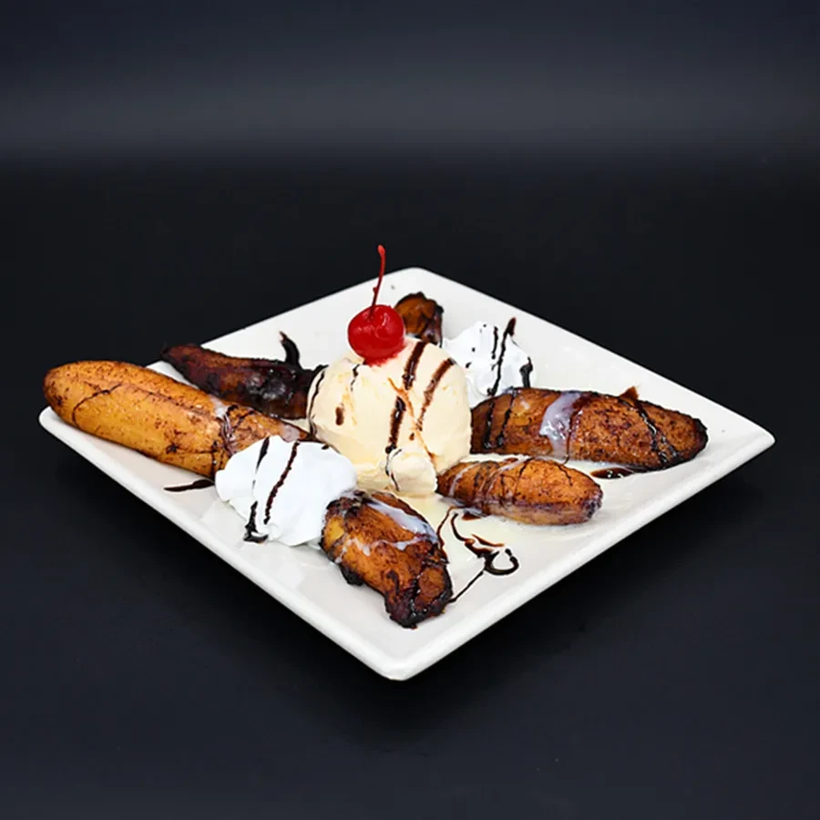 Fried plantains with vanilla ice cream, whipped cream, and chocolate syrup.