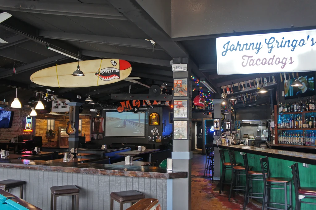 Eclectic surf/hot rod restaurant interior with bar, booths, and decor.
