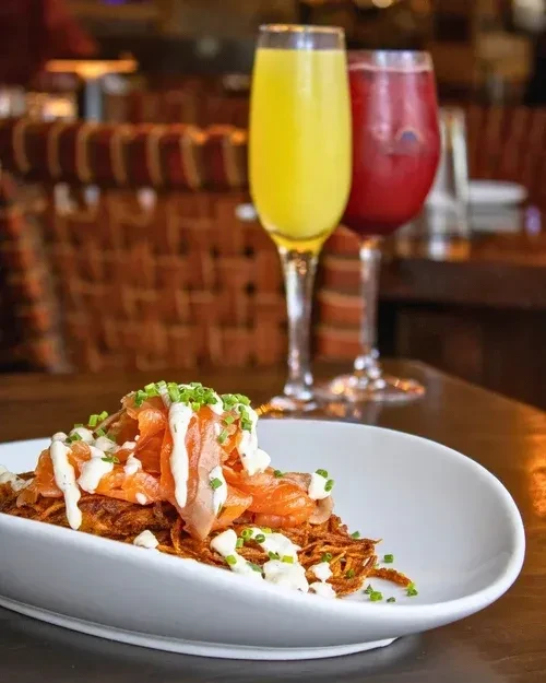 Crispy fried potatoes with smoked salmon, cream sauce, and chives.