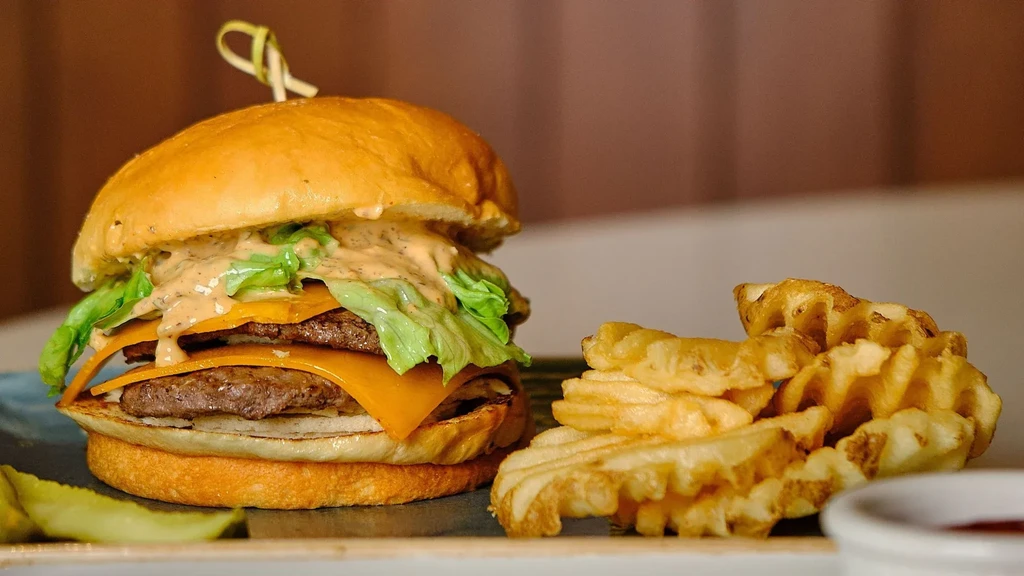 Double cheeseburger, waffle fries, pickle spear, and ketchup.
