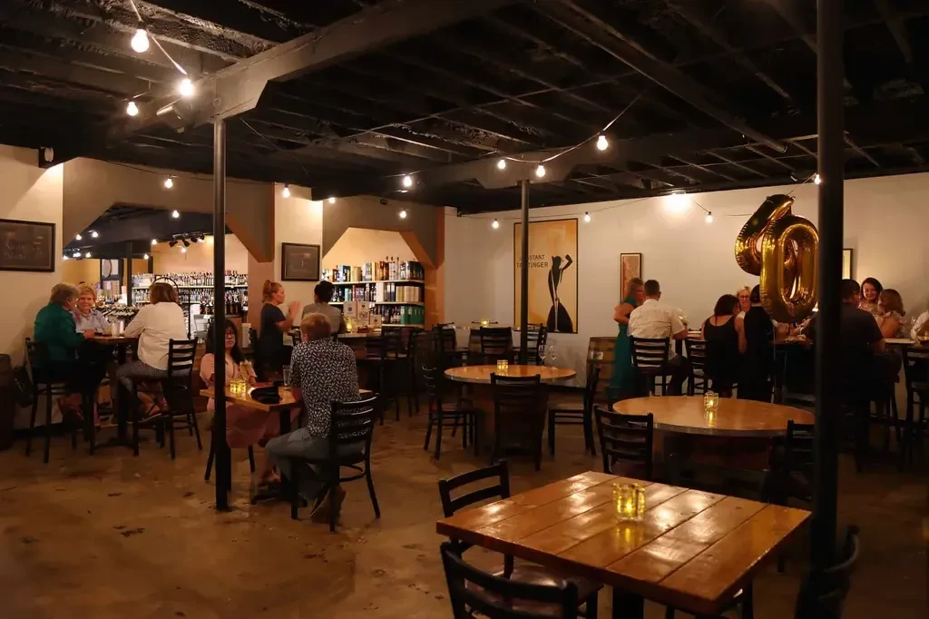Dimly lit casual restaurant interior showing groups celebrating with '60' balloons.