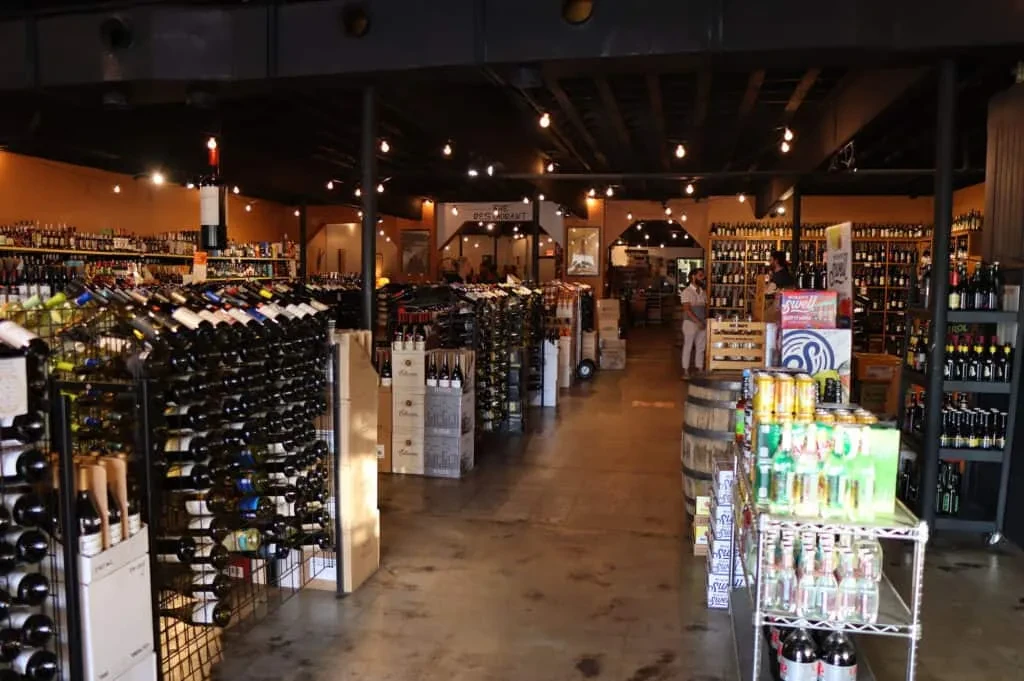 Spacious liquor store interior displaying numerous bottles of alcoholic drinks.