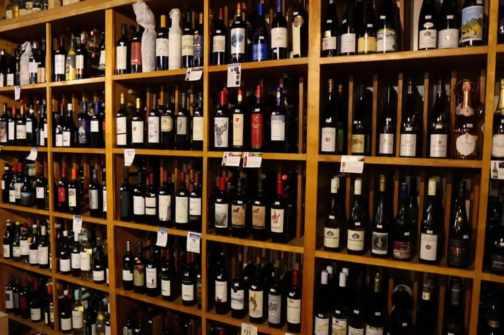 Extensive collection of wine bottles on multi-tiered wooden shelves.