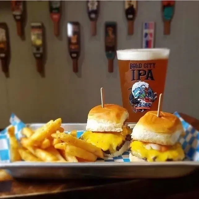 Two cheeseburger sliders, fries, and a pint of Bold City IPA.