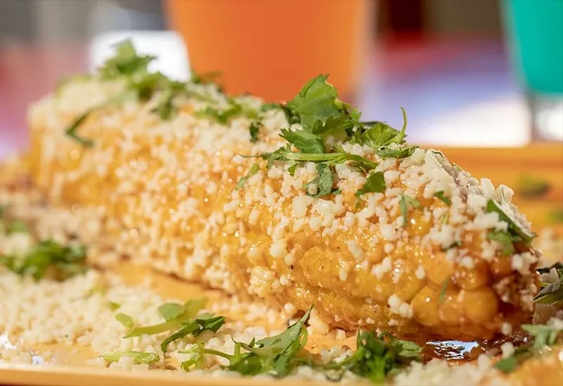 Elote (Mexican street corn) with creamy sauce, cotija cheese, and cilantro.