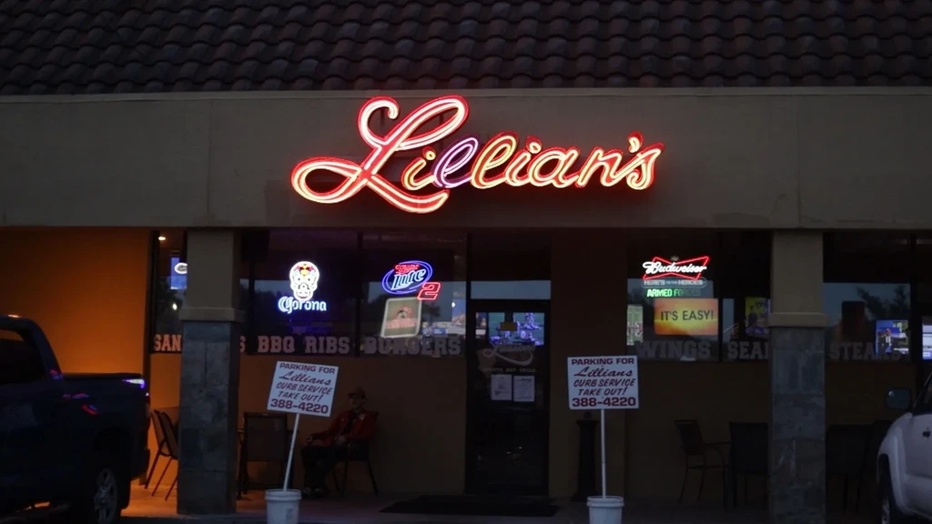 Lillian's restaurant's dark exterior at night with an ornate red neon sign.