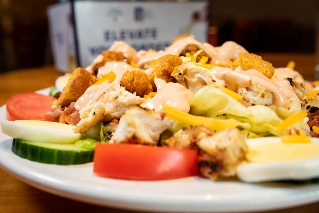 Grilled chicken salad with lettuce, eggs, tomatoes, and cucumber.