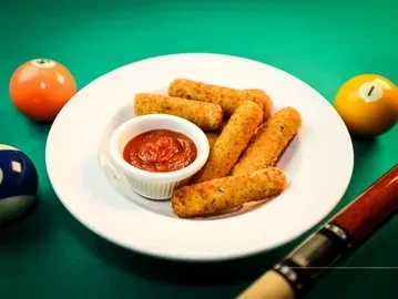 Mozzarella sticks and sauce on a pool table with billiard balls and cue.