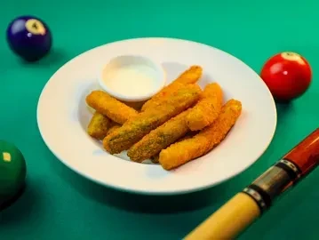 Fried pickle/zucchini sticks and dip on a billiard table.