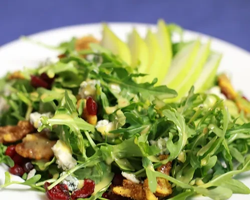 Gourmet salad with greens, creamy dressing, blue cheese, cranberries, and pear.