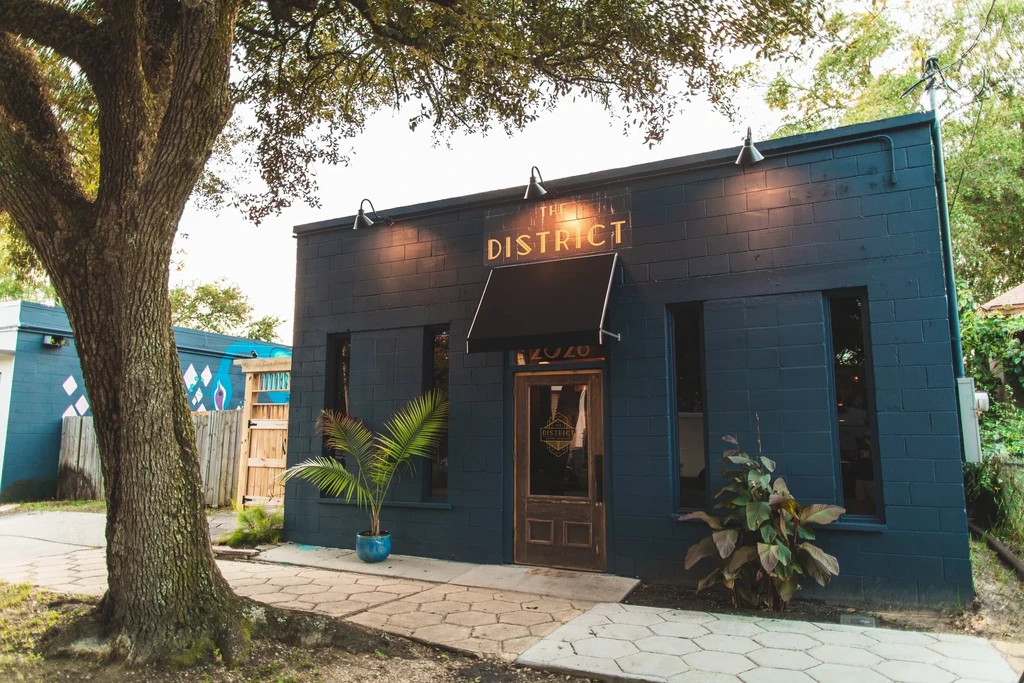 Exterior of THE DISTRICT, a modern dark-bricked restaurant building.