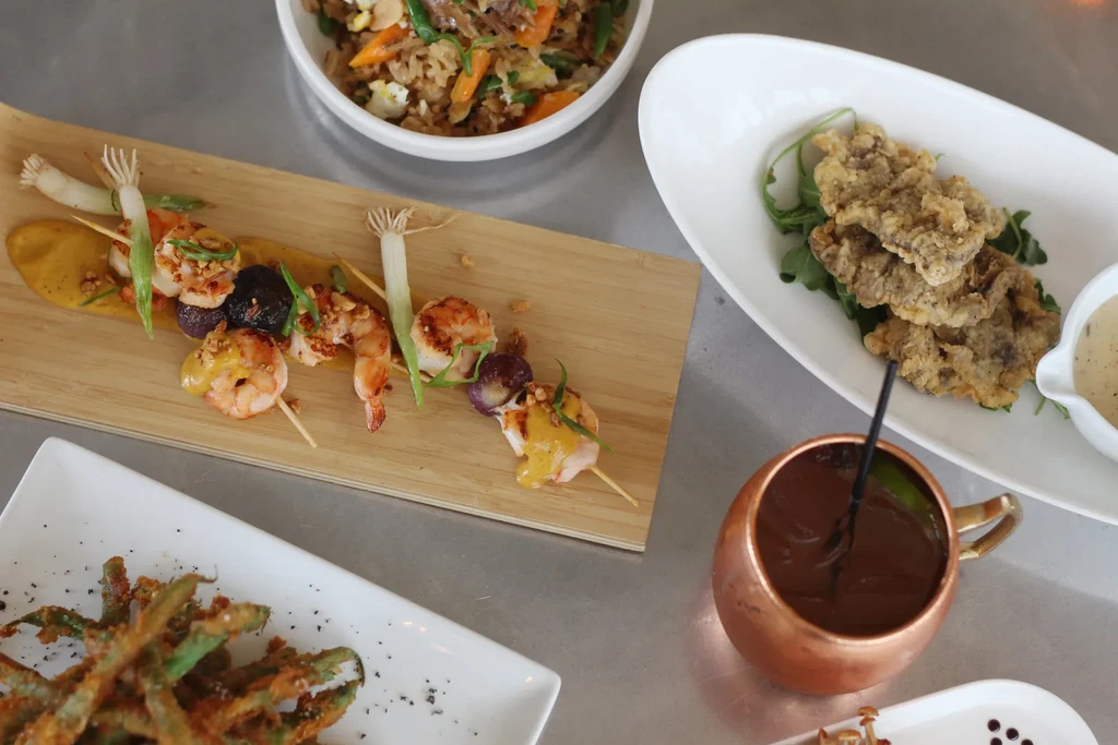 Overhead: shrimp skewers, fried rice, fried food, Moscow Mule.