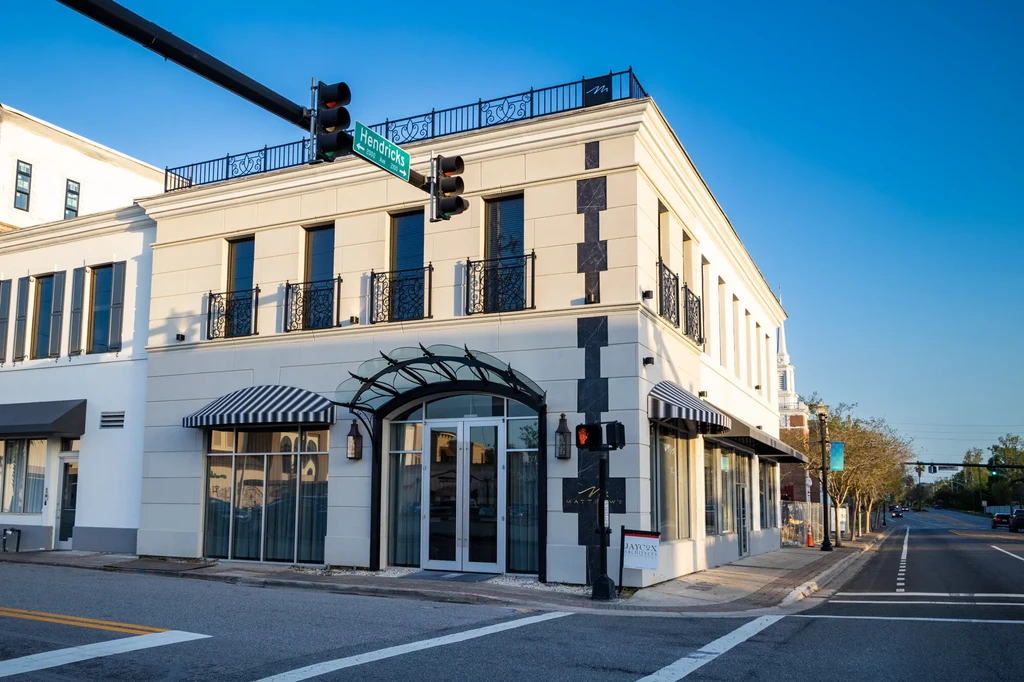 Exterior of Matthew's, a two-story corner building with stucco and ironwork.