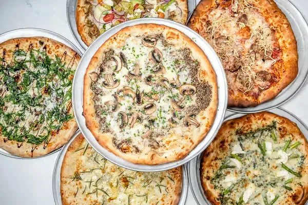 Six distinct pizzas with various toppings, viewed from above.