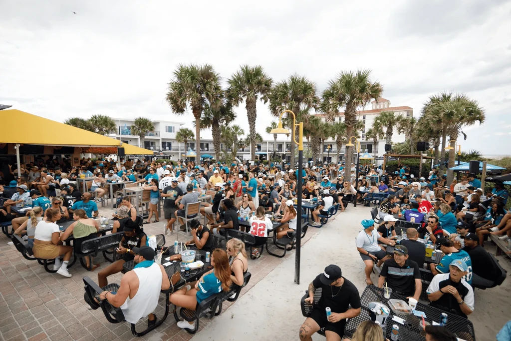 Outdoor resort restaurant crowded with people in Jaguars apparel.