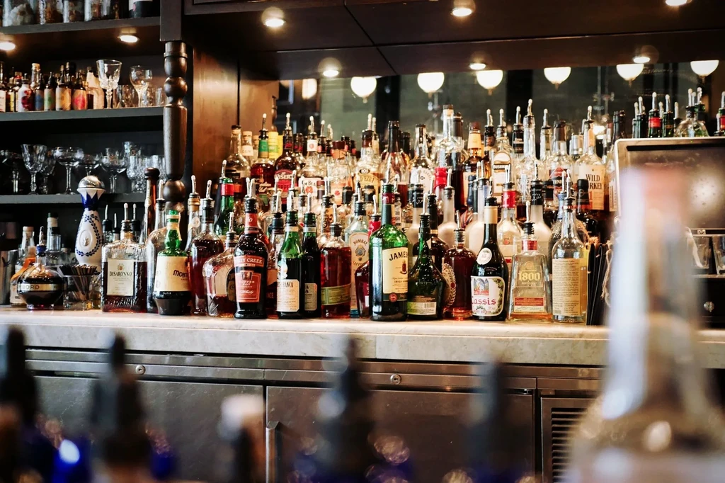 A well-stocked bar displaying numerous liquor bottles and clean glassware.
