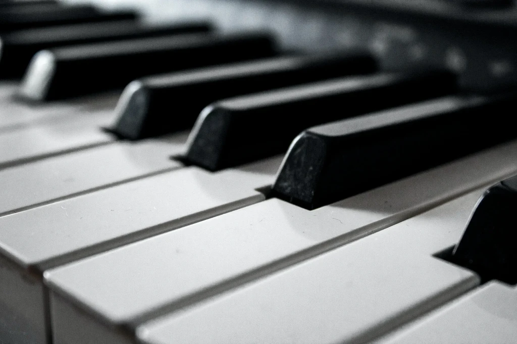Close-up of a piano keyboard, sharp focus on white and black keys.