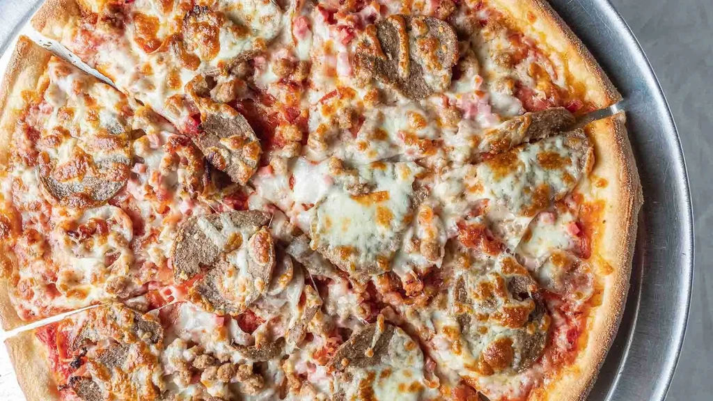 Pizza with sausage, pepperoni, melted cheese, two slices removed.