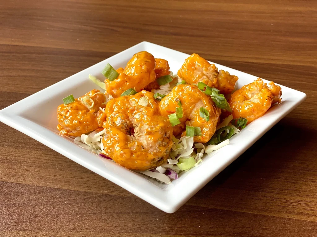 Breaded fried shrimp with creamy orange sauce, cabbage, and green onions.