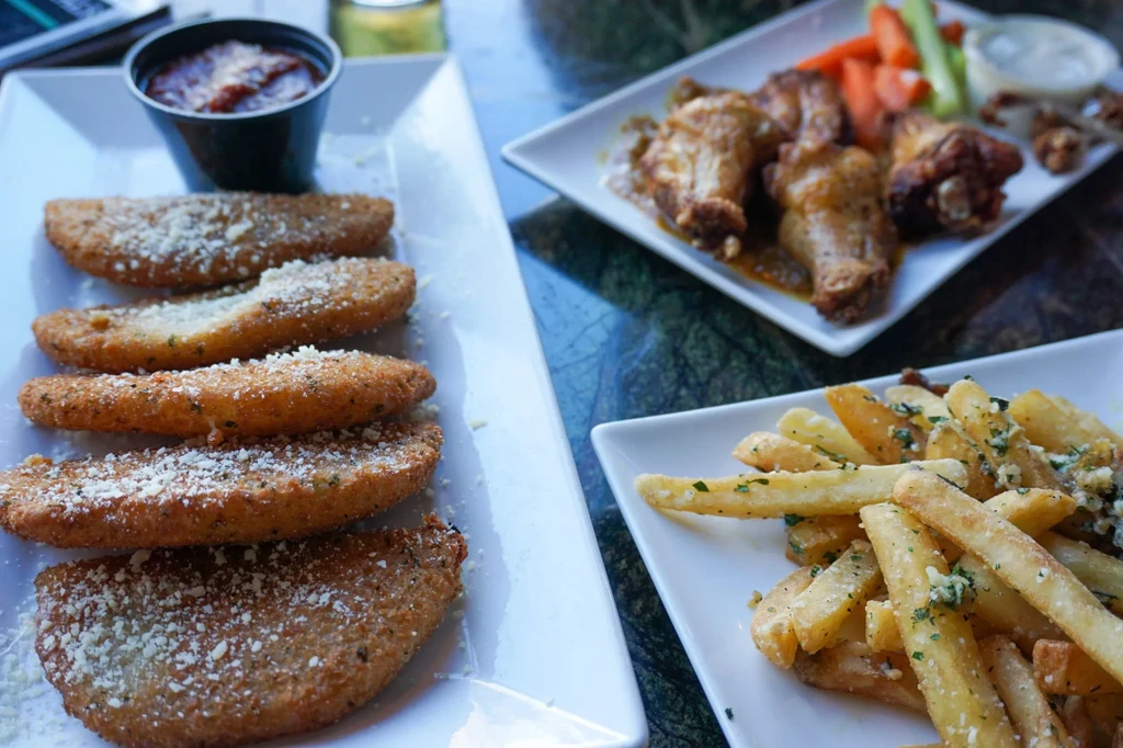 Overhead: Cheesy fried items, chicken wings, and french fries.