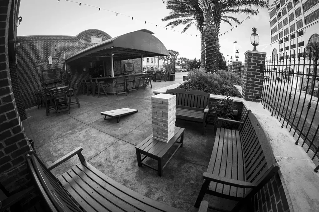 Black and white patio bar, empty, with games and string lights.