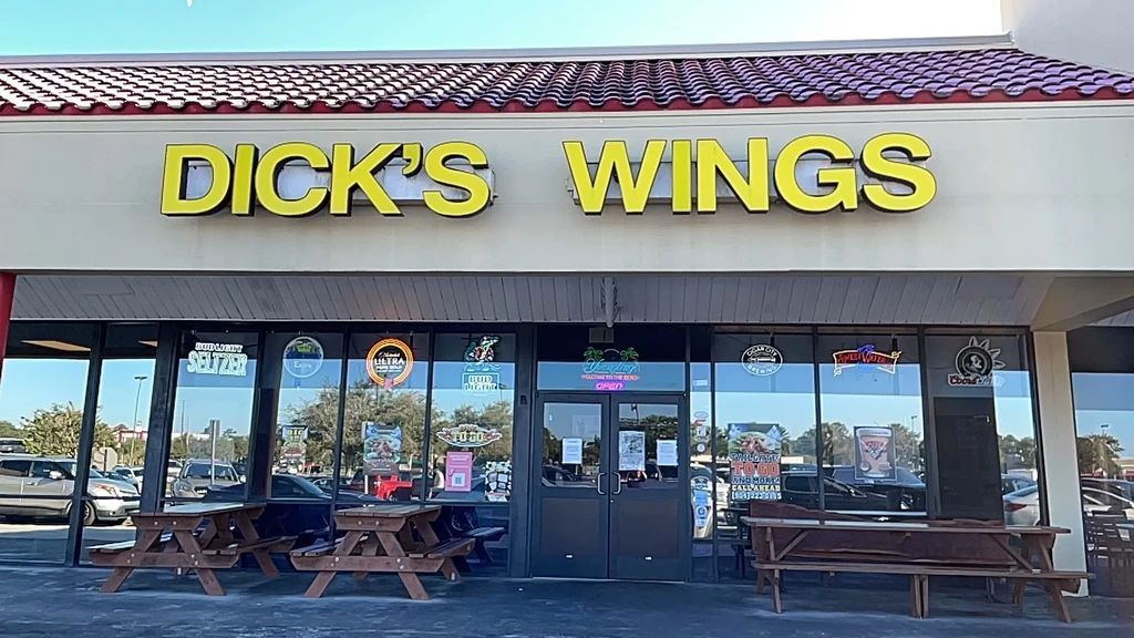 DICK'S WINGS restaurant exterior with outdoor picnic tables.