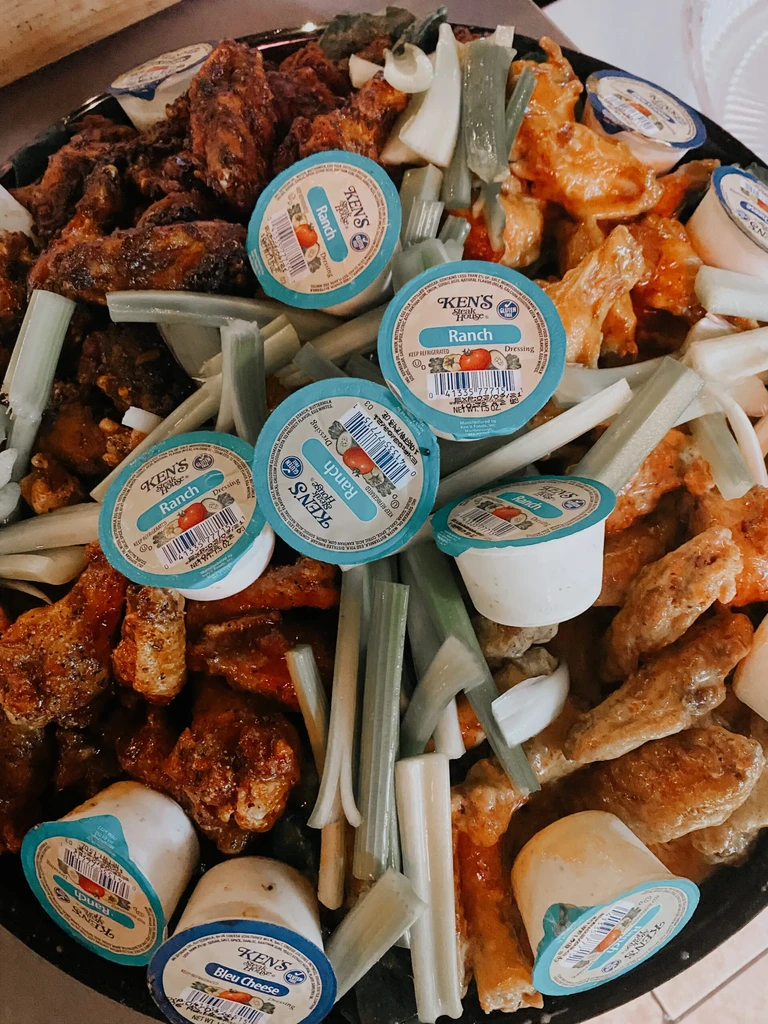 Tray with chicken wings, celery sticks, and branded Ranch/Bleu Cheese.