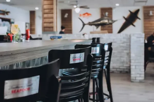 Restaurant bar with "Southern Coast SEAFOOD" stools and fish decor.