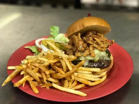 Hamburger with cheese, crispy onions, pickles, and golden fries.