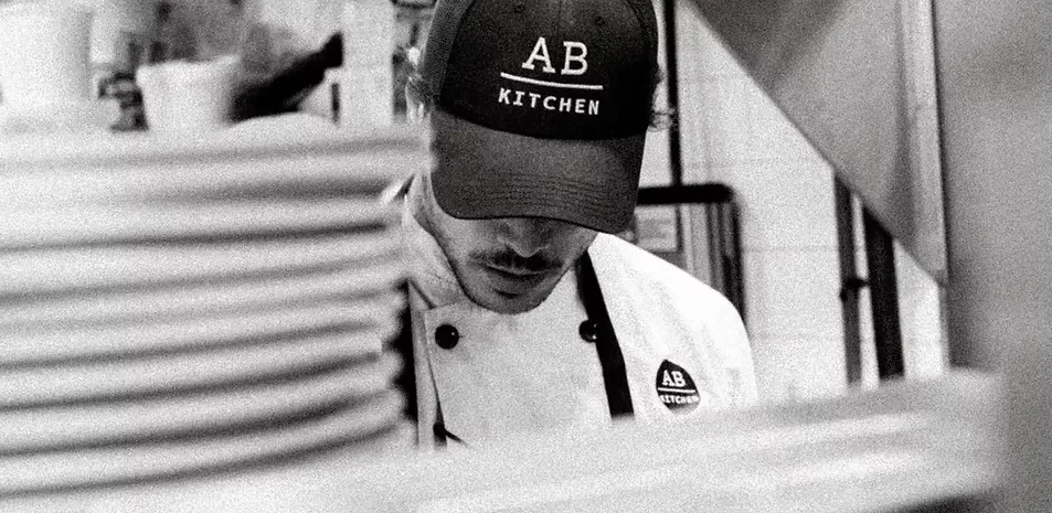 Grainy black and white photo of an AB Kitchen chef at work.