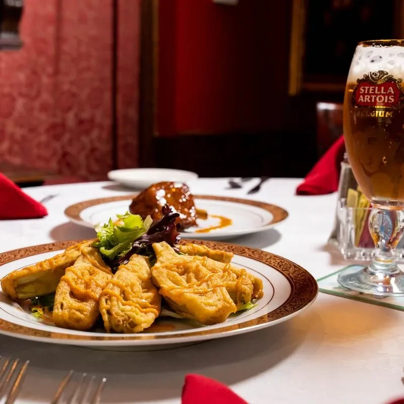 Fried appetizers, Stella Artois beer, and a main course in a restaurant.