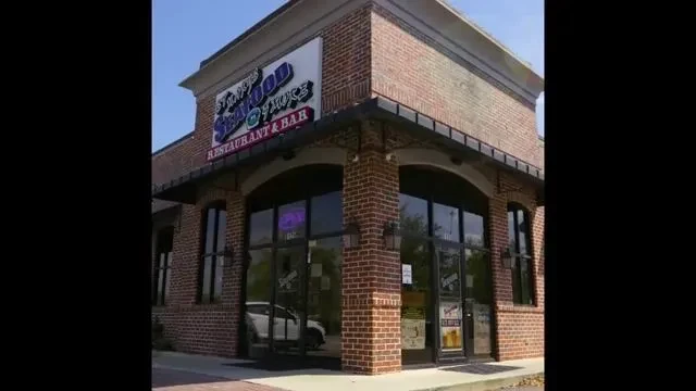 Exterior of St. 1973 Seafood & Juice, a brick corner restaurant.