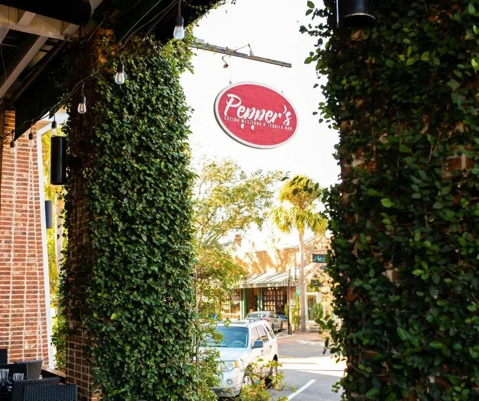 Pepper's Cocina Mexicana entrance with ivy-covered columns and strung lights.