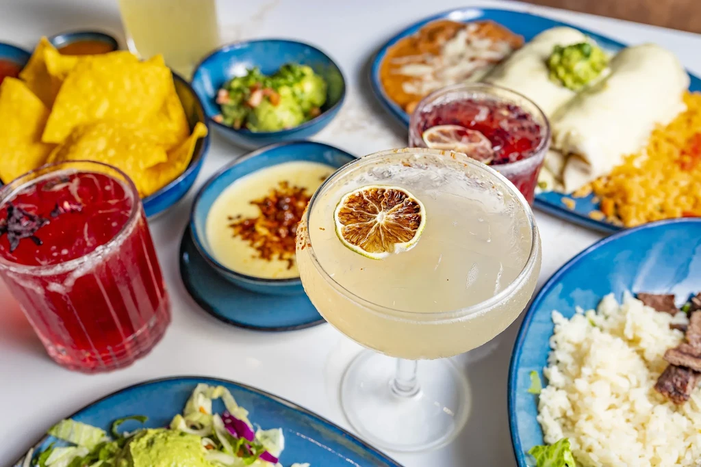 Overhead view of a table with diverse Mexican dishes and drinks.